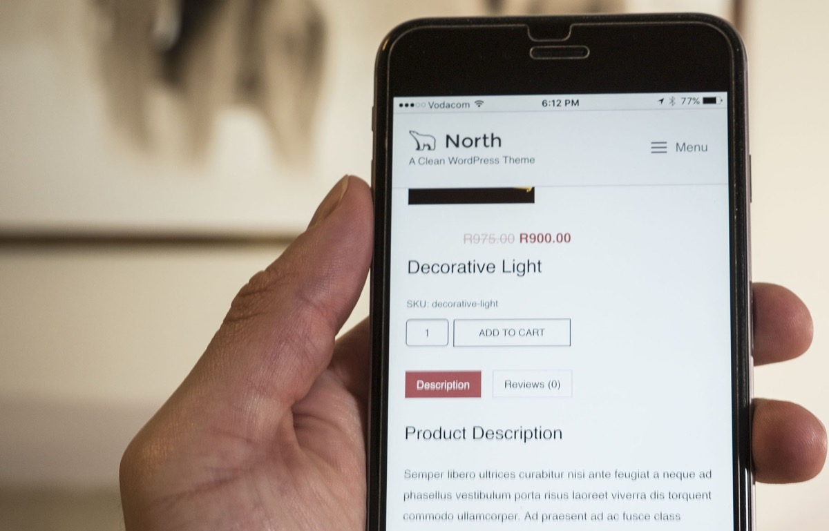 North theme responsive WooCommerce product page on a mobile phone held in hand