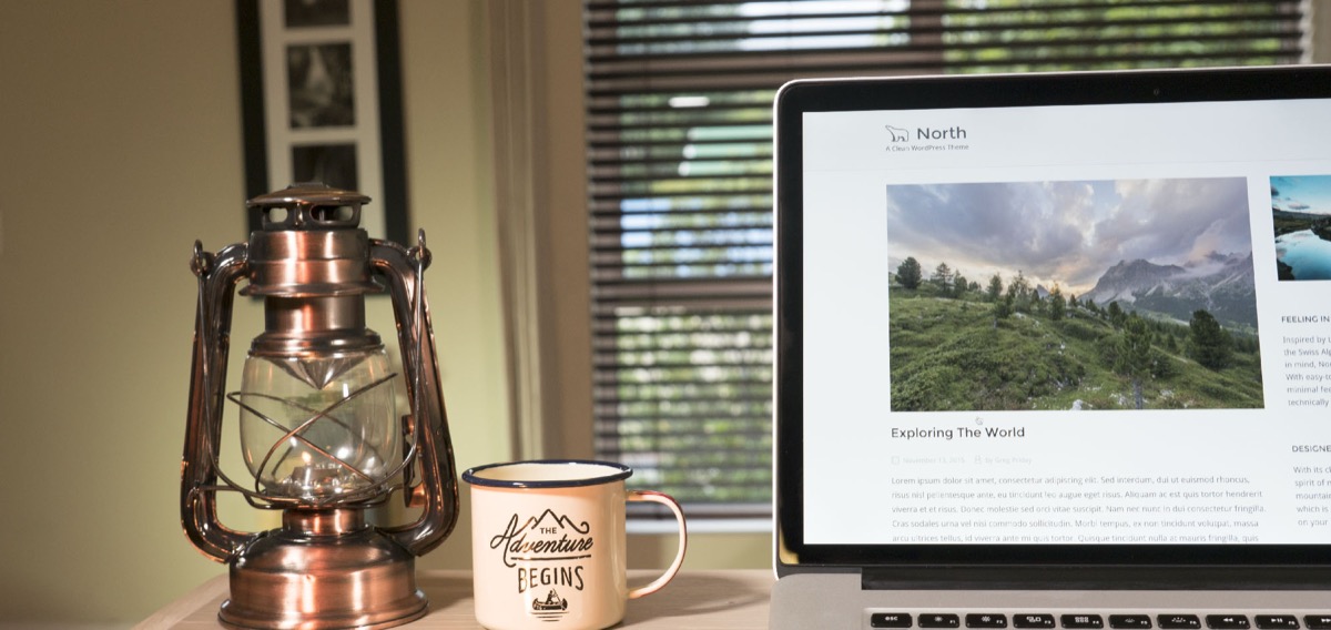 North theme displayed on a laptop beside a vintage lantern and adventure coffee mug