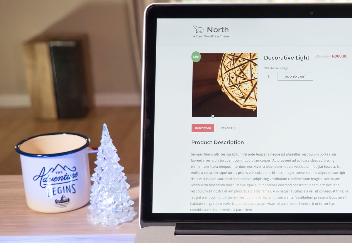 North theme WooCommerce product page displayed on a laptop with a coffee mug and decorative tree